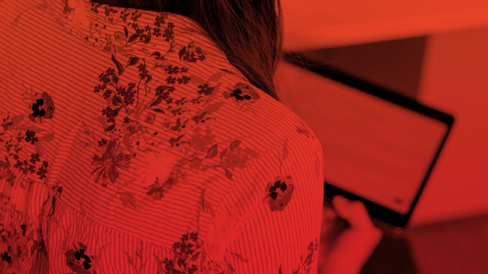 A woman's shoulder with a floral pattern using a tablet