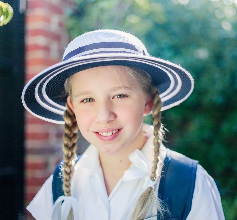 APAC girl with pigtail braids in uniform with hat