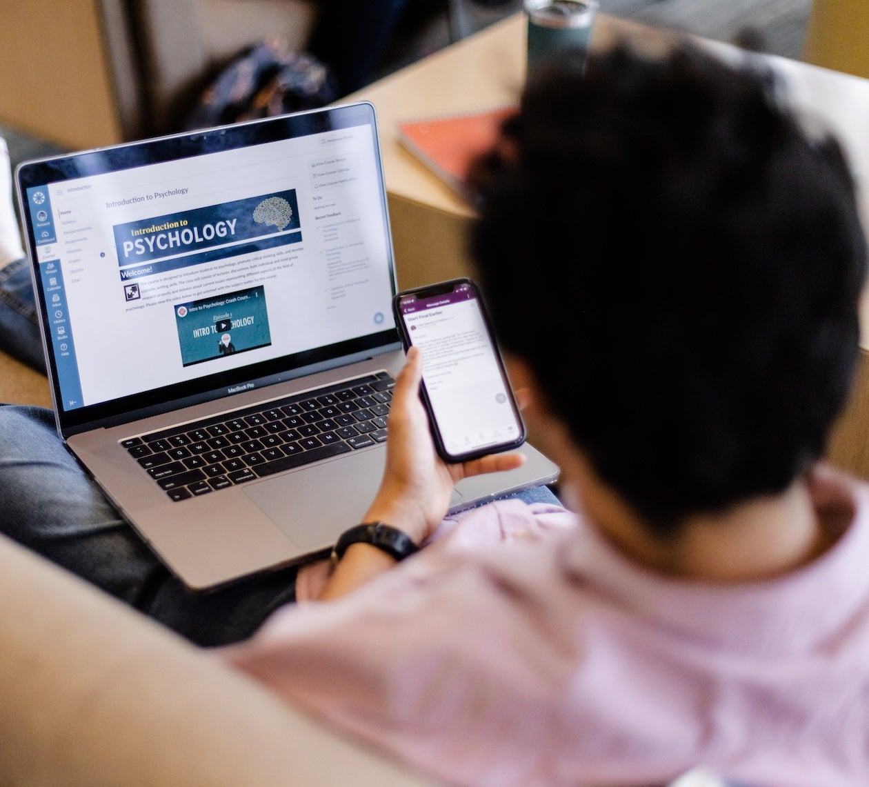 Man using Canvas LMS on laptop & phone