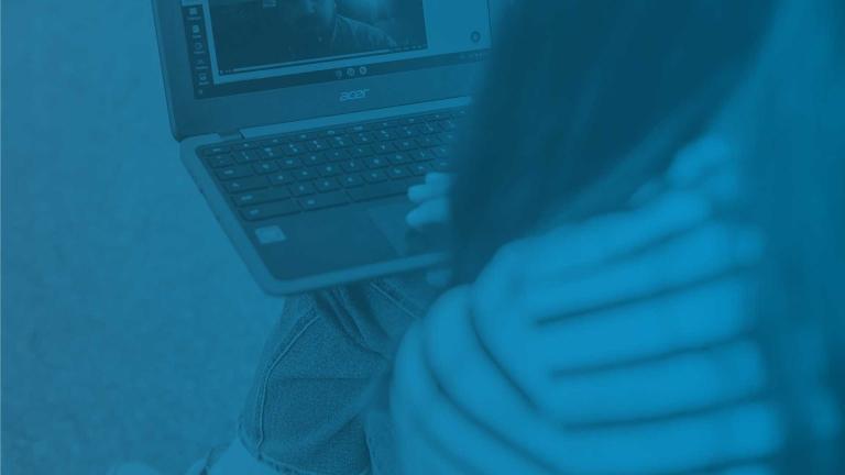 image taken of a girl on a laptop from behind with a blue overlay