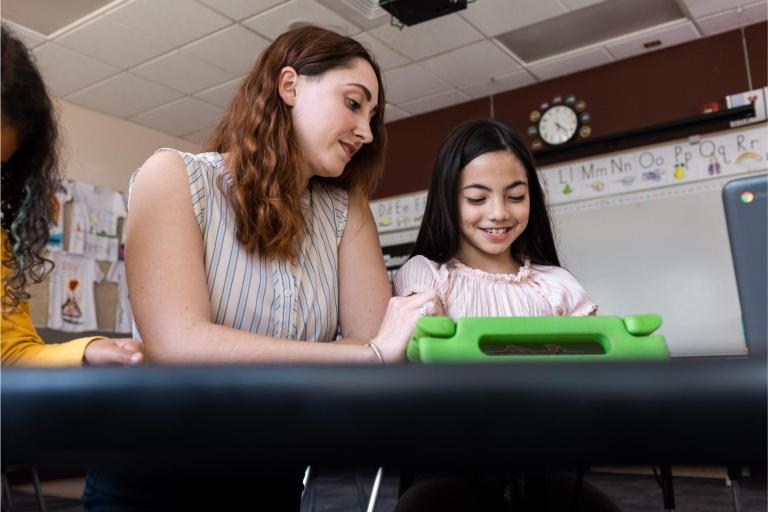 Teacher helps students learn using digital tools