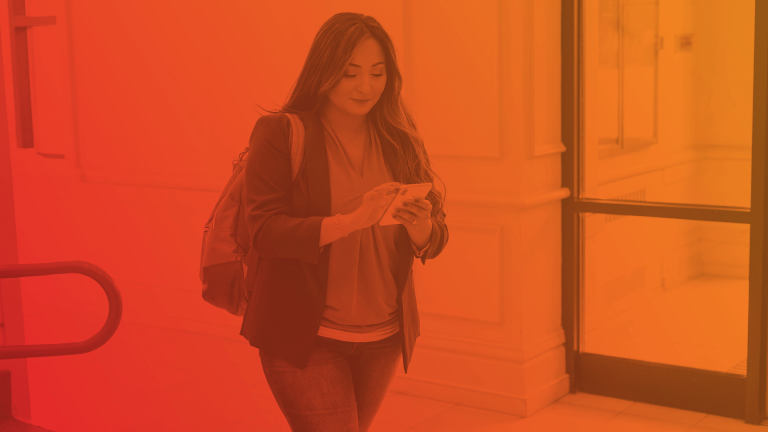 woman reads her phone in an academic setting