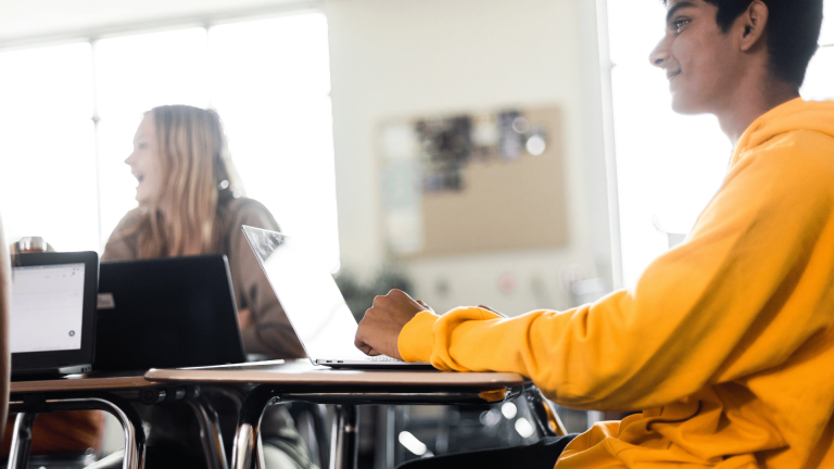 students sitting at desks with computers in front of them