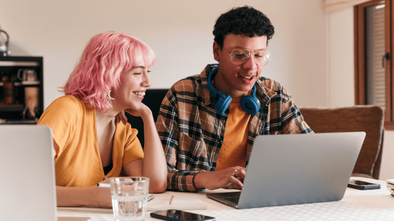 two people looking at a laptop